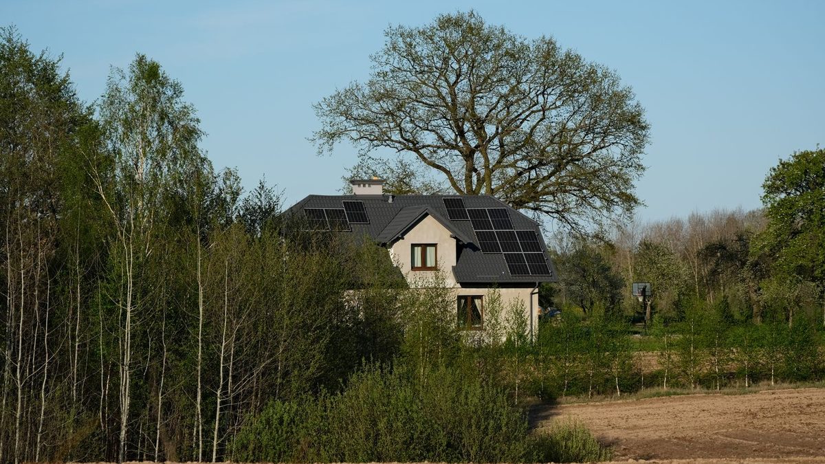 Hus med solceller på taket omgivet av grönska